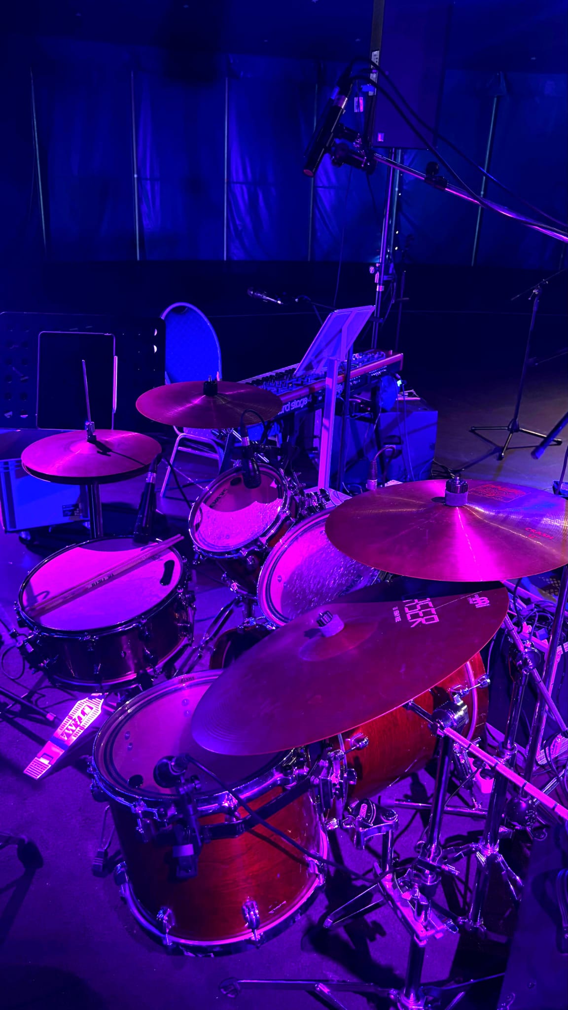 Close-up of the drum kit under purple stage light